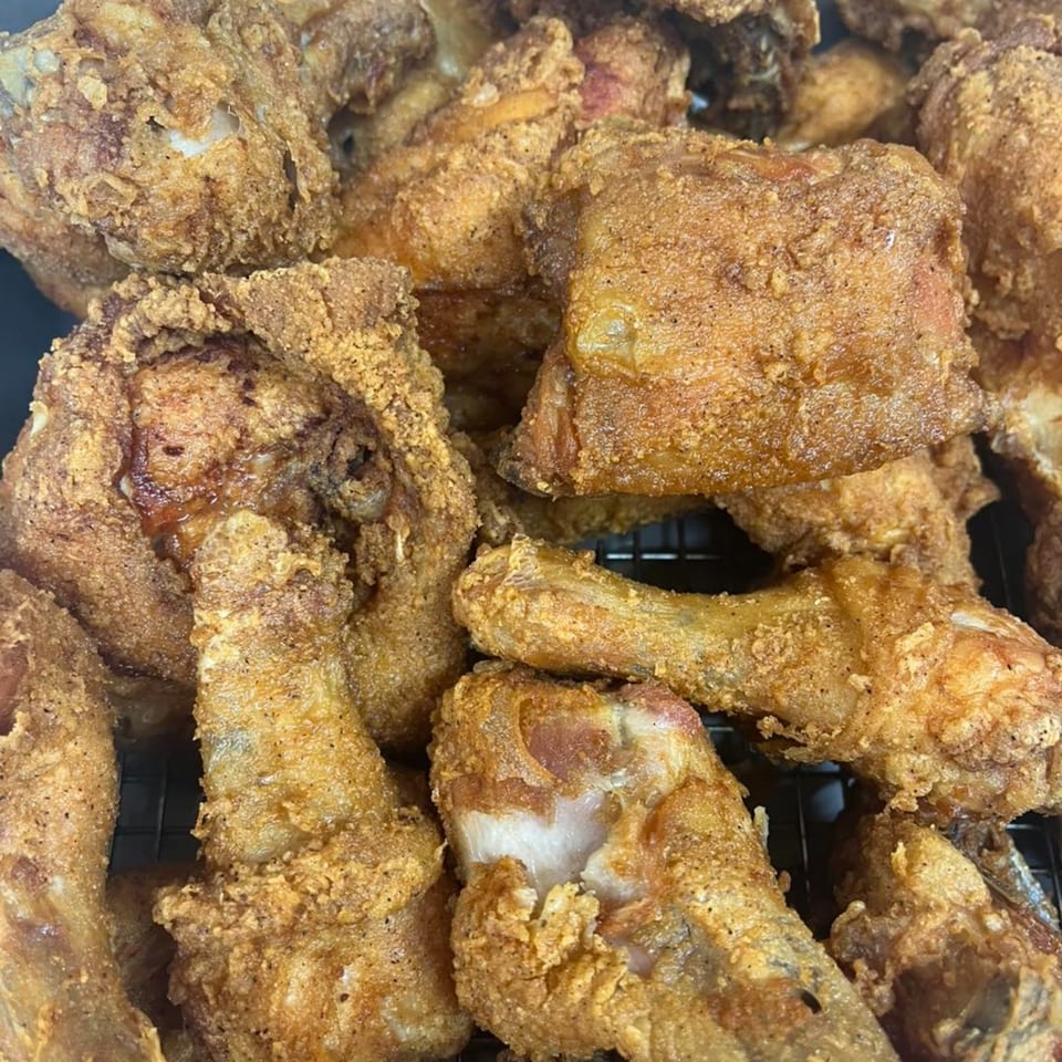 Close-up of a pile of golden-brown fried chicken pieces from Pa's Chicken Coupe.